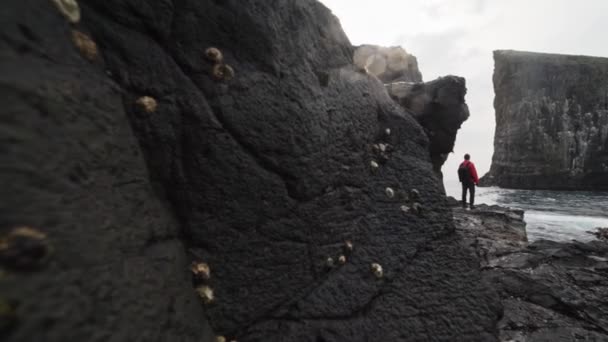 Rocas grandes a impresionantes paisajes Drangarnir y el hombre mirando a la vista — Vídeos de Stock