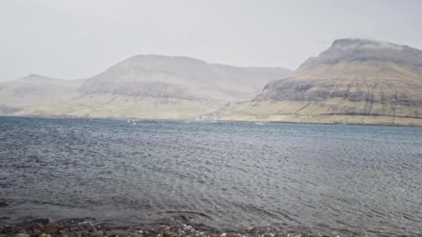 Scénický pohled z skalnatých břehů oceánských vod a kopců na Faerském ostrově — Stock video