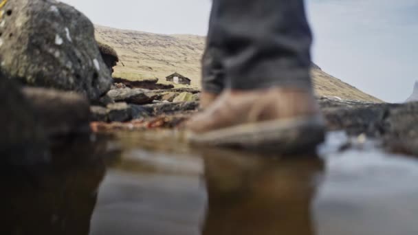 Low-Angled Schot met Man 's Benen Walking Voorbij de Camera en Hill in de achtergrond — Stockvideo
