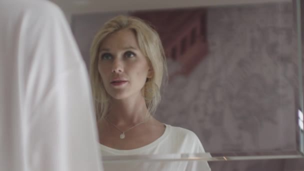 Blondynka młoda kobieta patrząc w pokoju hotelowym lustro — Wideo stockowe