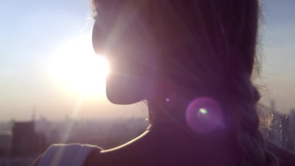 Jeune femme blonde jouissant de la lumière du soleil au coucher du soleil — Video