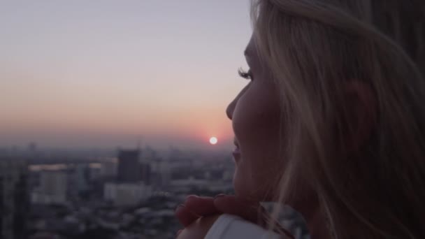 Jeune femme blonde jouissant de la lumière du soleil au coucher du soleil — Video