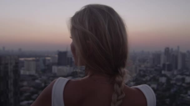 Jeune femme blonde jouissant de la lumière du soleil au coucher du soleil — Video