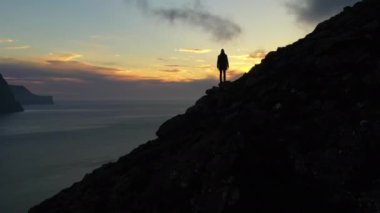 Gün batımında Villingadalsjall Dağı 'ndaki Adam Üzerine İnsansız Hava Aracı