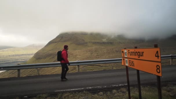 Wanderer passieren Verkehrszeichen auf Vidareidi — Stockvideo