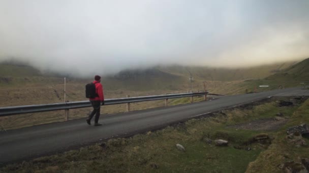 Randonneur marchant le long de la route sur Vidareidi — Video