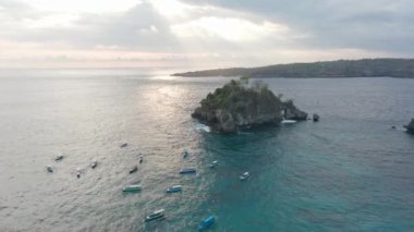 Güneş ışığı Nusa Penida 'daki güzel ve sakin okyanus sularına yansıyor.