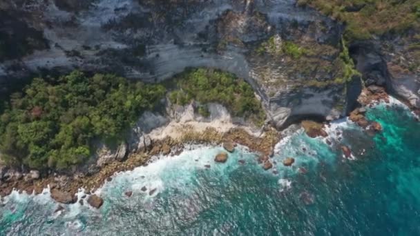 Letecký snímek vln narážejících na skalnaté hlubiny na pláži na Bali, Indonésie — Stock video