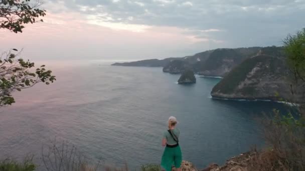 Kobieta Turystka stojąca nad krawędzią klifu do podziwiania ogromnych wód Oceanu — Wideo stockowe