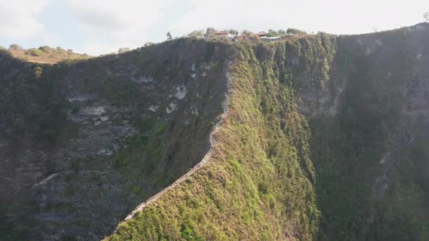 Cliff v Nusa Penida Island, Bali s malou vesnicí na vrcholu — Stock video