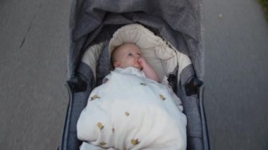 Bebek Kız 'ın Hareket Eden Bebek Arabasında Başparmak Emici videosu.