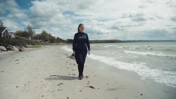Mujer caucásica vistiendo zapatillas y caminando en las costas arenosas de la playa — Vídeos de Stock