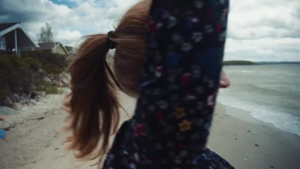 Glimlachende dame die de hand van de man vasthoudt en ronddraait bij het strand — Stockvideo