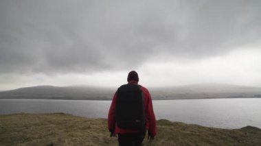 Sırt çantalı gezgin peyzaja bakmak için yürüyor