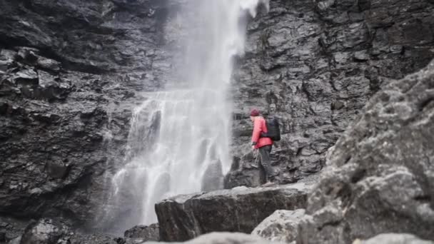 Wandelaar op rotsen onder Fossa waterval — Stockvideo