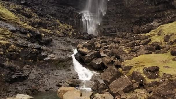 Agua en cascada desde el borde del acantilado en las rocas por debajo — Vídeos de Stock