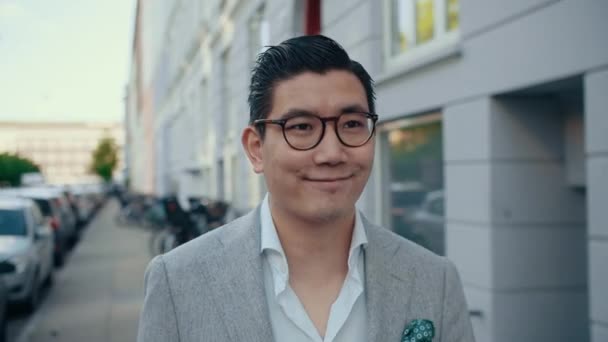 Gülümseyen Koreli İş Adamı Şehirde Yürüyor — Stok video