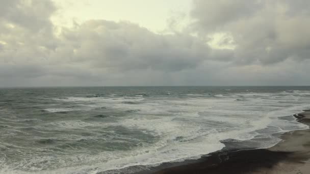 Céus e ondas nublados batendo contra as profundezas rasas da costa da praia — Vídeo de Stock