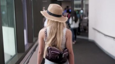 Blonde modelinin havalimanı biniş kapısına yaklaşan görüntüsü.