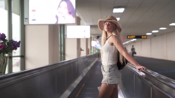 Красивая женщина на дорожке аэропорта с телефоном в одной руке — стоковое видео