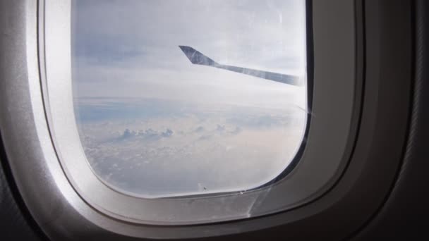 Blick auf Wolken und Flügel aus dem Flugzeugfenster — Stockvideo