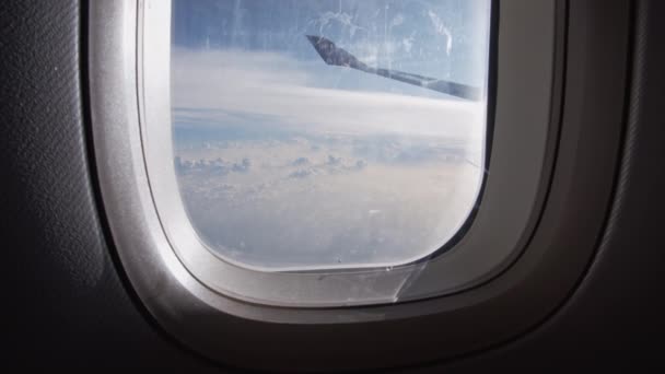 飛行機の窓の後ろに見える白い雲と青い空 — ストック動画
