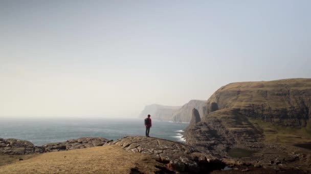 Människan med utsikt över havet och dramatiska landskap — Stockvideo