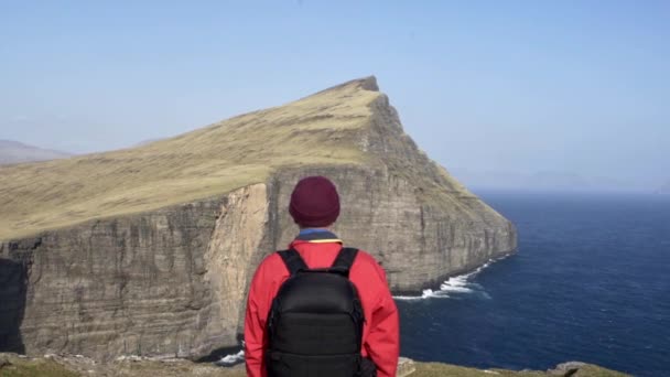 Турист смотрит на скалы и береговую линию — стоковое видео