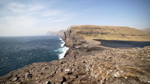 Caminante parado en acantilados rocosos sobre el mar — Vídeos de Stock