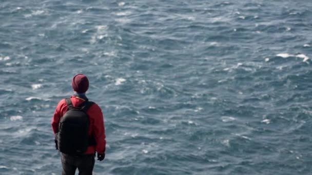 Ember figyeli az óceánt a part menti sziklákról — Stock videók