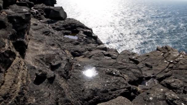 Piscina de roca que brilla con luz solar en acantilados — Vídeo de stock