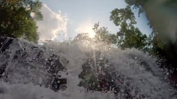 Вода из водопадов и солнечный свет на фоне голубого неба — стоковое видео