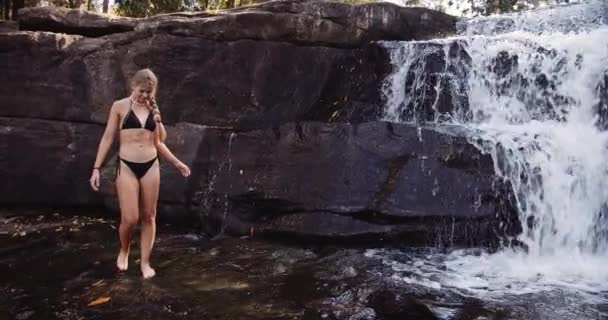 Pretty Female Model Walking by the Rocks with Waterfalls in Background — Stock Video