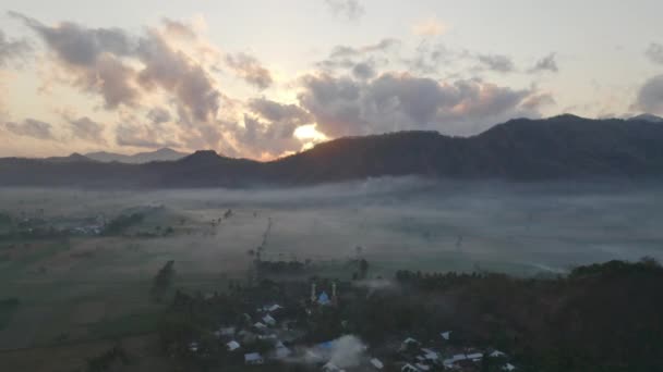 Foresta montana e sole arancione brillante che sbircia dietro le nuvole bianche, Indonesia — Video Stock