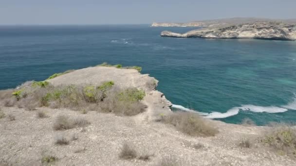 Colpo aereo di donna che si arrampica sulla scogliera con vista sull'oceano Vista sull'acqua — Video Stock