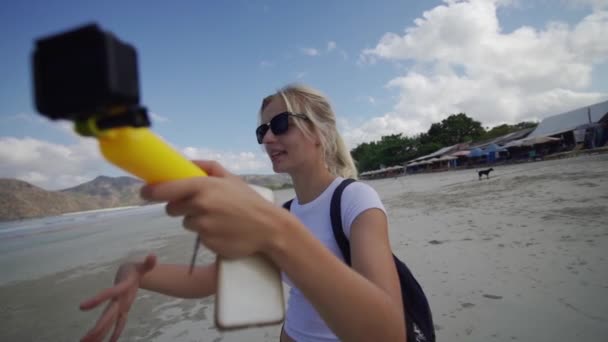 Kobieta Podróżujący Nagrywanie wideo z widokiem na plażę i góry w tle — Wideo stockowe