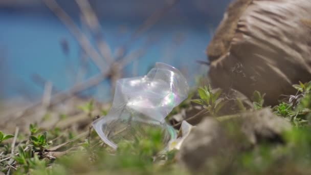 Coupe en plastique usagée écrasée et laissée dans le sol avec des eaux Lombok — Video