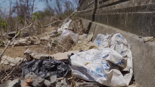 Spazzatura Sinistra sdraiata sul calcestruzzo circondata da macerie e ramoscelli secchi — Video Stock