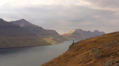 Dağlık araziye bakmak üzere duran yürüyüşçünün Drone görüntüsü