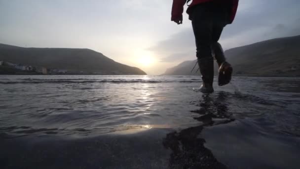 Sığ gölde yürüyen adam Gündoğumuna doğru — Stok video