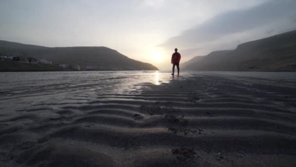 Homme sur le banc de sable du lac ondulé au lever du soleil — Video