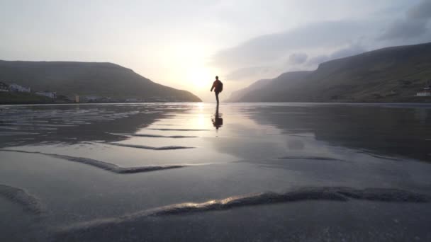 Homme marchant au lever du soleil à travers le lac peu profond — Video