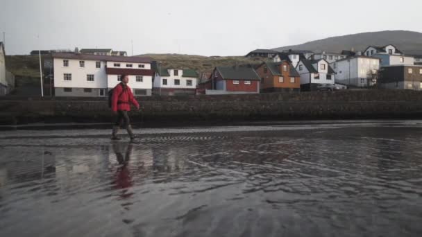 Wandelaar wandelen door ondiep water door de stad — Stockvideo