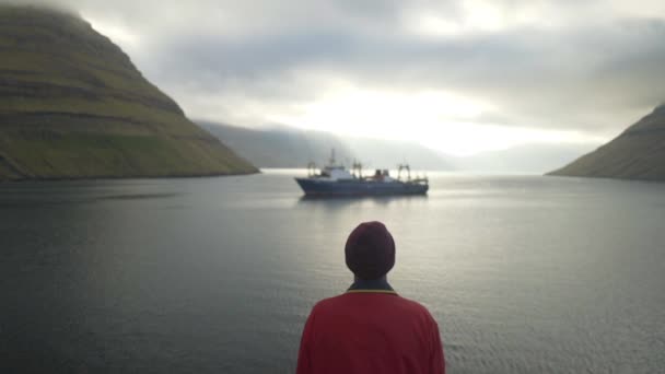 Caminhante observando navio em Sorvagsvatn ou Leitisvatn — Vídeo de Stock