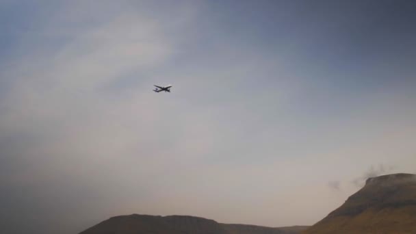 Avion volant dans le ciel bleu nuageux de l'île Féroé — Video