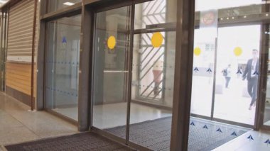 Havaalanındaki adam terminalin giriş kapısından biniş kartıyla geçiyor.