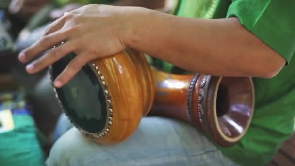 Tiro focado dos braços do homem como ele toca os tambores de mão tailandeses — Vídeo de Stock