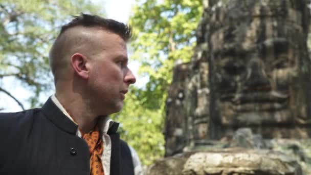 Турист в Байонском храме со знаменитыми развалинами Будды — стоковое видео