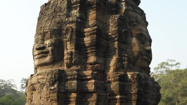 Caras sonrientes talladas en un monumento de piedra en el templo de Angkor Wat en Camboya — Vídeo de stock