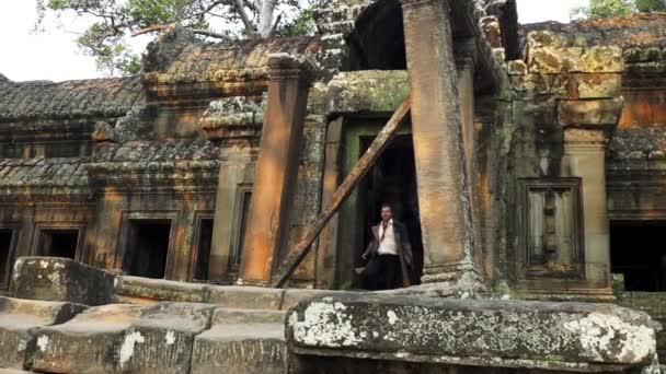 Slowmo βίντεο του ανθρώπου τρέχει έξω που προέρχονται από το ναό της Καμπότζης ερείπια — Αρχείο Βίντεο